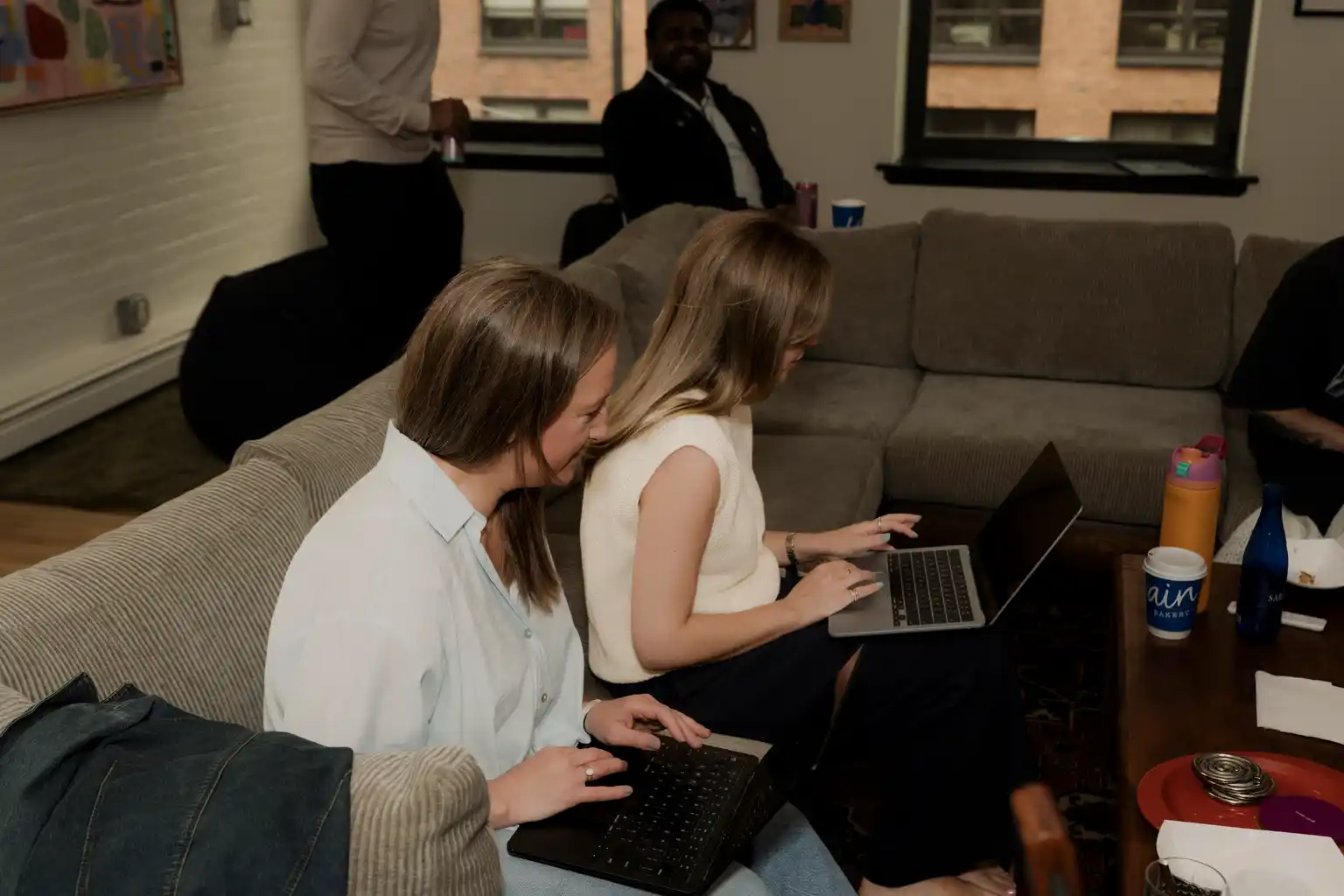 Teammates working side by side on laptops during the offsite
